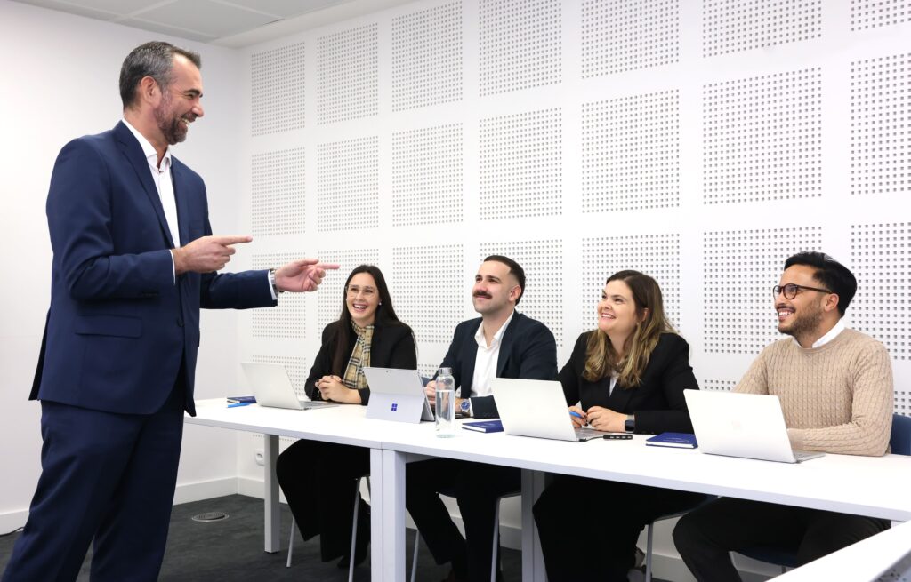 Reunião de equipa em contexto empresarial durante apresentação sobre envolvimento e produtividade no trabalho